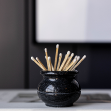 Load image into Gallery viewer, Black vase with wooden sticks on a book titled 'The Art of Home'.