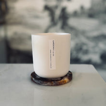 Load image into Gallery viewer, White candle in a glass container on a marble surface with a blurred background