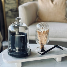 Load image into Gallery viewer, A styled interior scene showing a marble tray holding a black candle under a clear glass cloche and a twisted clear glass vase with a black-and-white striped candle on top, set in front of a beige sofa.
