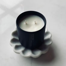 Load image into Gallery viewer, Black candle in a decorative holder on a white surface
