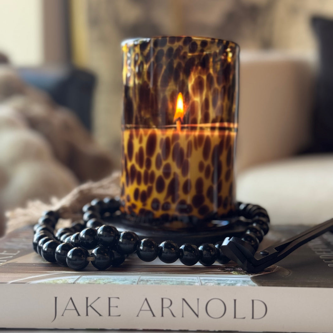 Leopard print candle on a book with a blurred background
