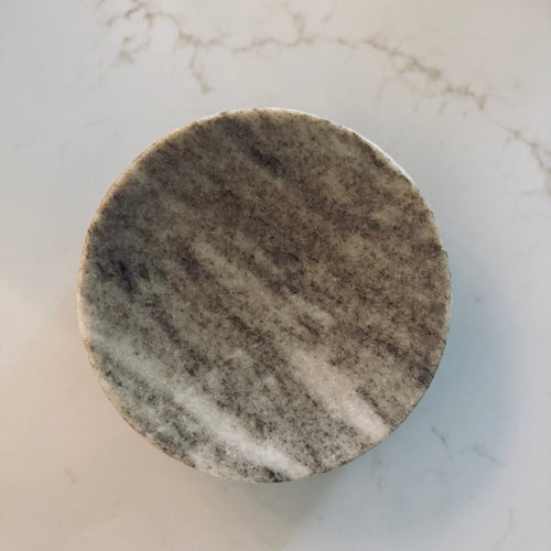 Round marble coaster on a marble surface