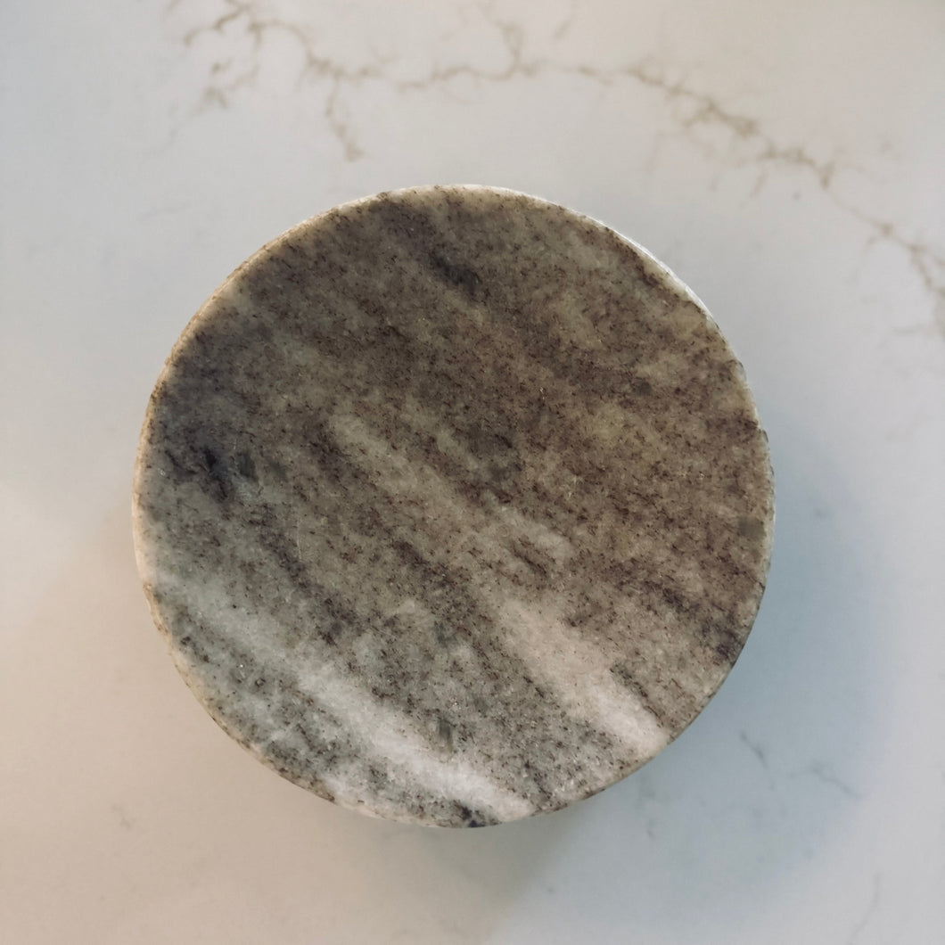 Round marble coaster on a marble surface