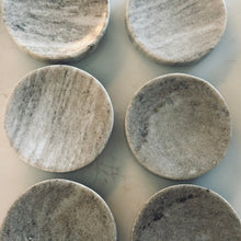 Load image into Gallery viewer, Six round stone coasters with a marbled pattern on a light gray background
