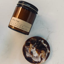 Load image into Gallery viewer, Brown candle with a label on a marble surface
